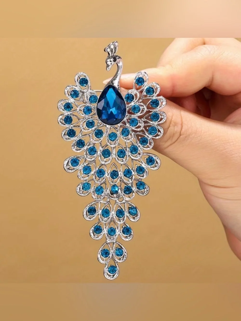 sparkling peacock-shaped statement brooch featuring blue crystals silver-tone